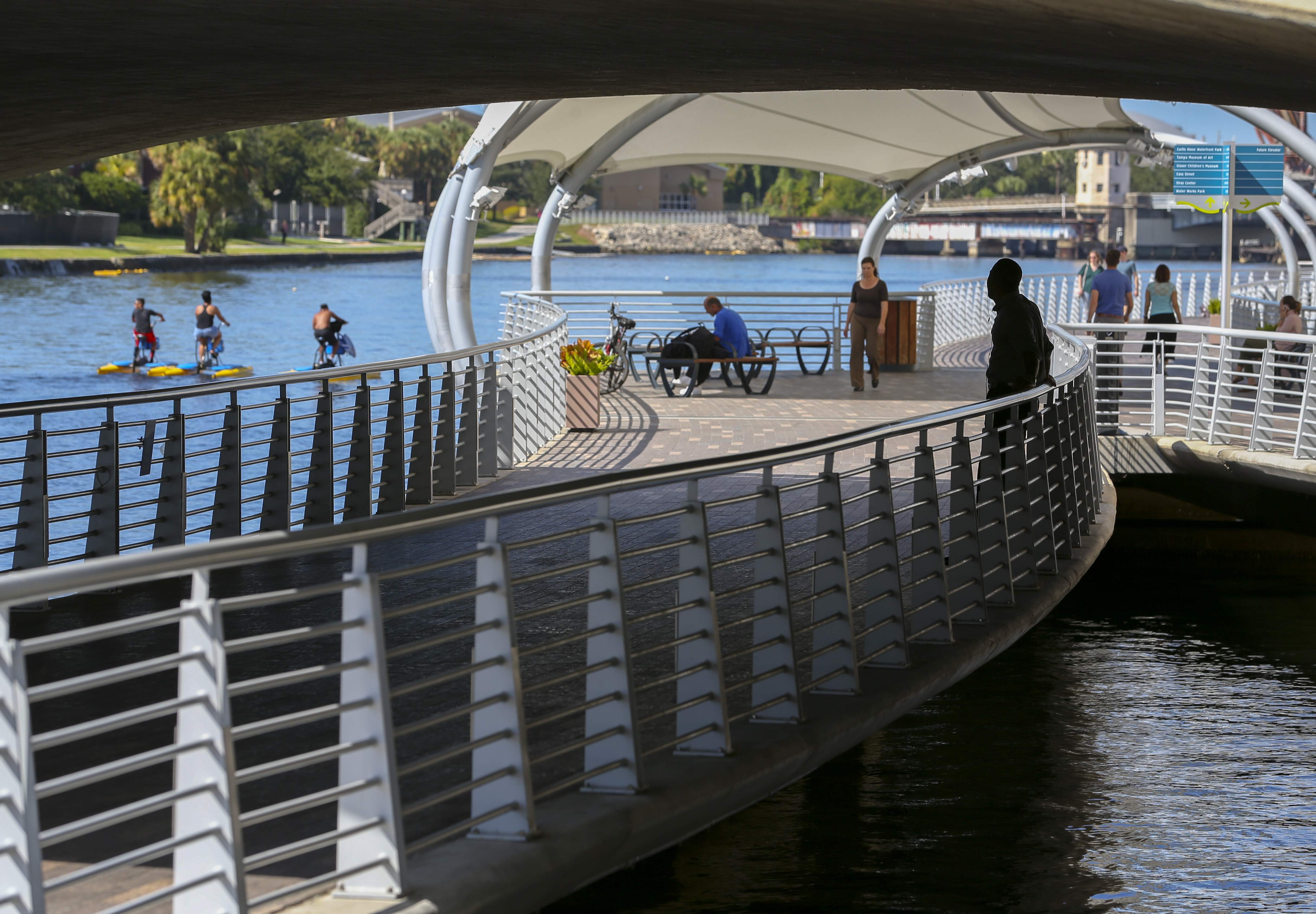 Pedestrians and water bike riders enjoy the Riverwalk in downtown Tampa. Pedestrians and water bike riders enjoy the Riverwalk in downtown Tampa.