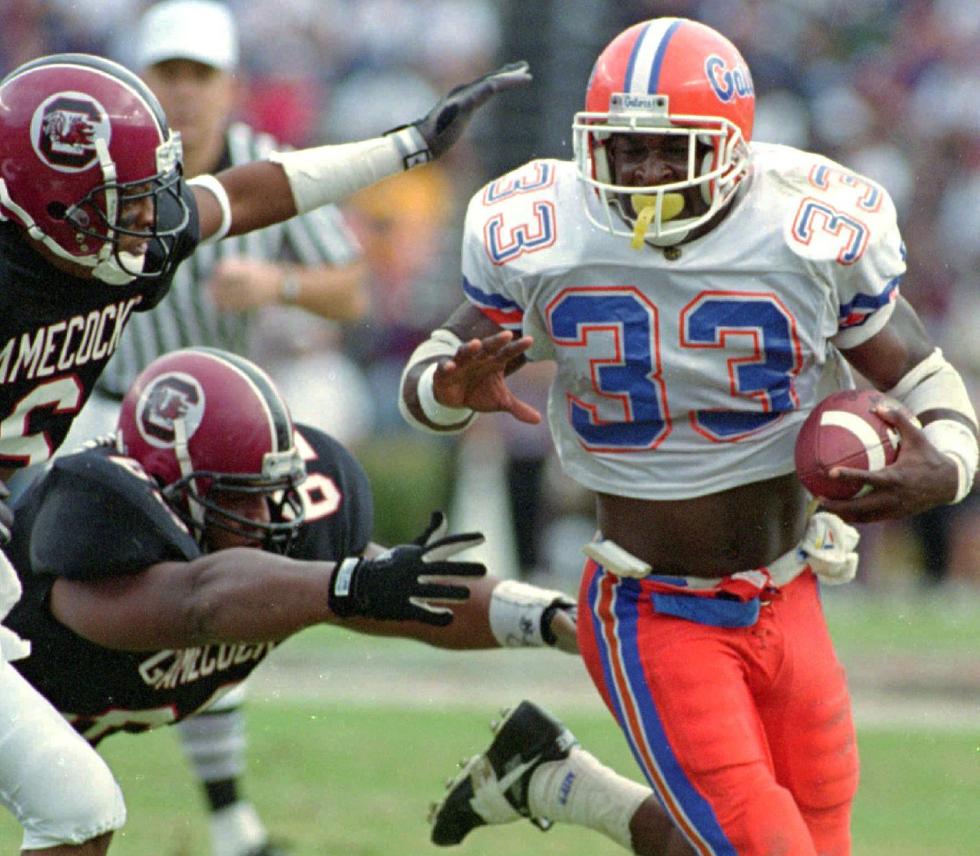 Florida's Errict Rhett (33) looks for running room as South Carolina players Norman Greene, left, and Eric Sullivan (diving) reach for him during a 1993 game. (AP Photo/Renee Ittner McManus) Florida's Errict Rhett (33) looks for running room as South Carolina players Norman Greene, left, and Eric Sullivan (diving) reach for him during a 1993 game. (AP Photo/Renee Ittner McManus)