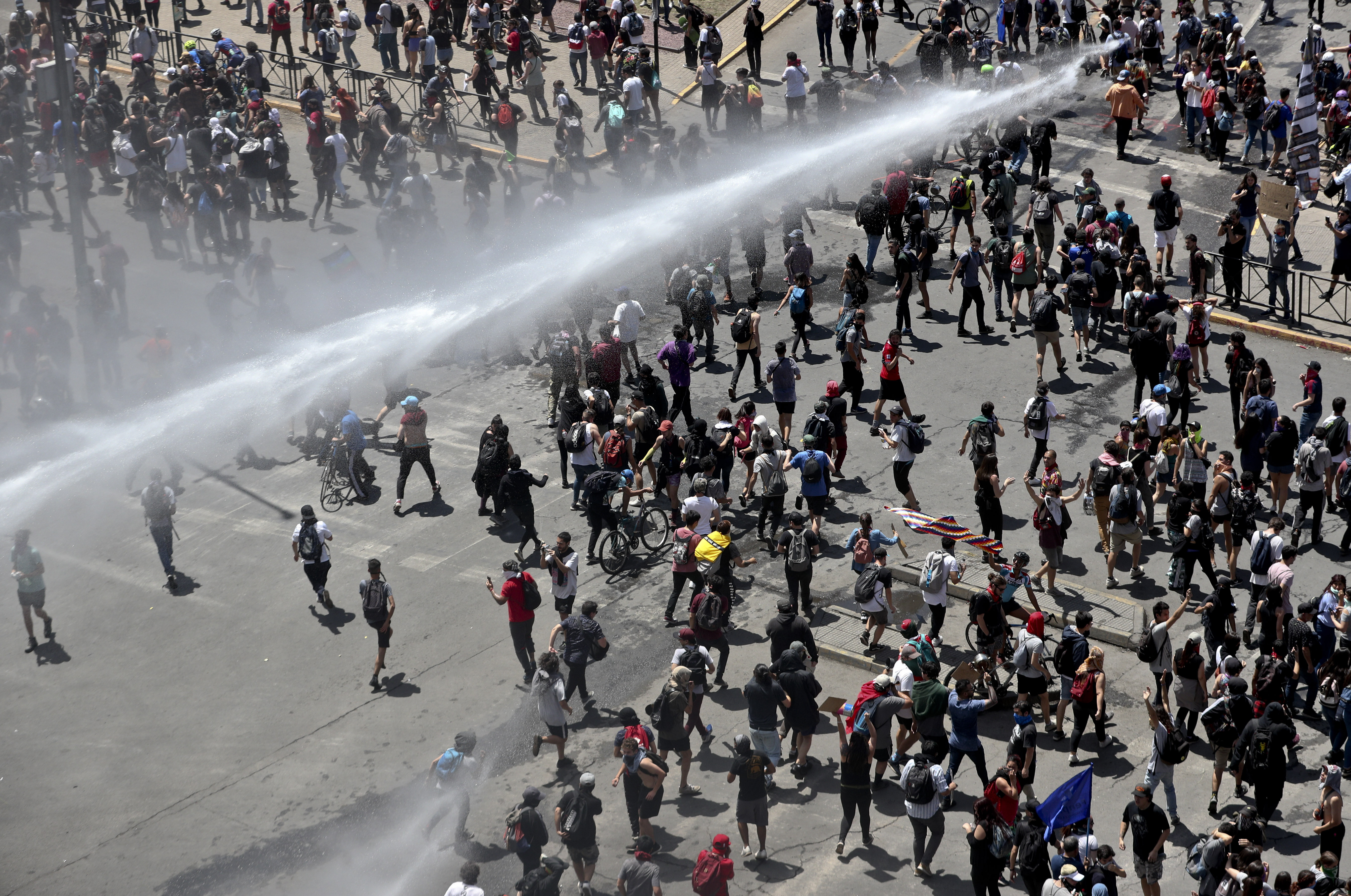 A police water cannon charges a crowd of anti-government demonstrators during a protest in Santiago, Chile, Tuesday, Oct. 22, 2019. Chile has been facing days of unrest, triggered by a relatively minor increase in subway fares. The protests have shaken a nation noted for economic stability over the past decades, which has seen steadily declining poverty despite persistent high rates of inequality. Esteban Felix | AP A police water cannon charges a crowd of anti-government demonstrators during a protest in Santiago, Chile, Tuesday, Oct. 22, 2019. Chile has been facing days of unrest, triggered by a relatively minor increase in subway fares. The protests have shaken a nation noted for economic stability over the past decades, which has seen steadily declining poverty despite persistent high rates of inequality. Esteban Felix | AP