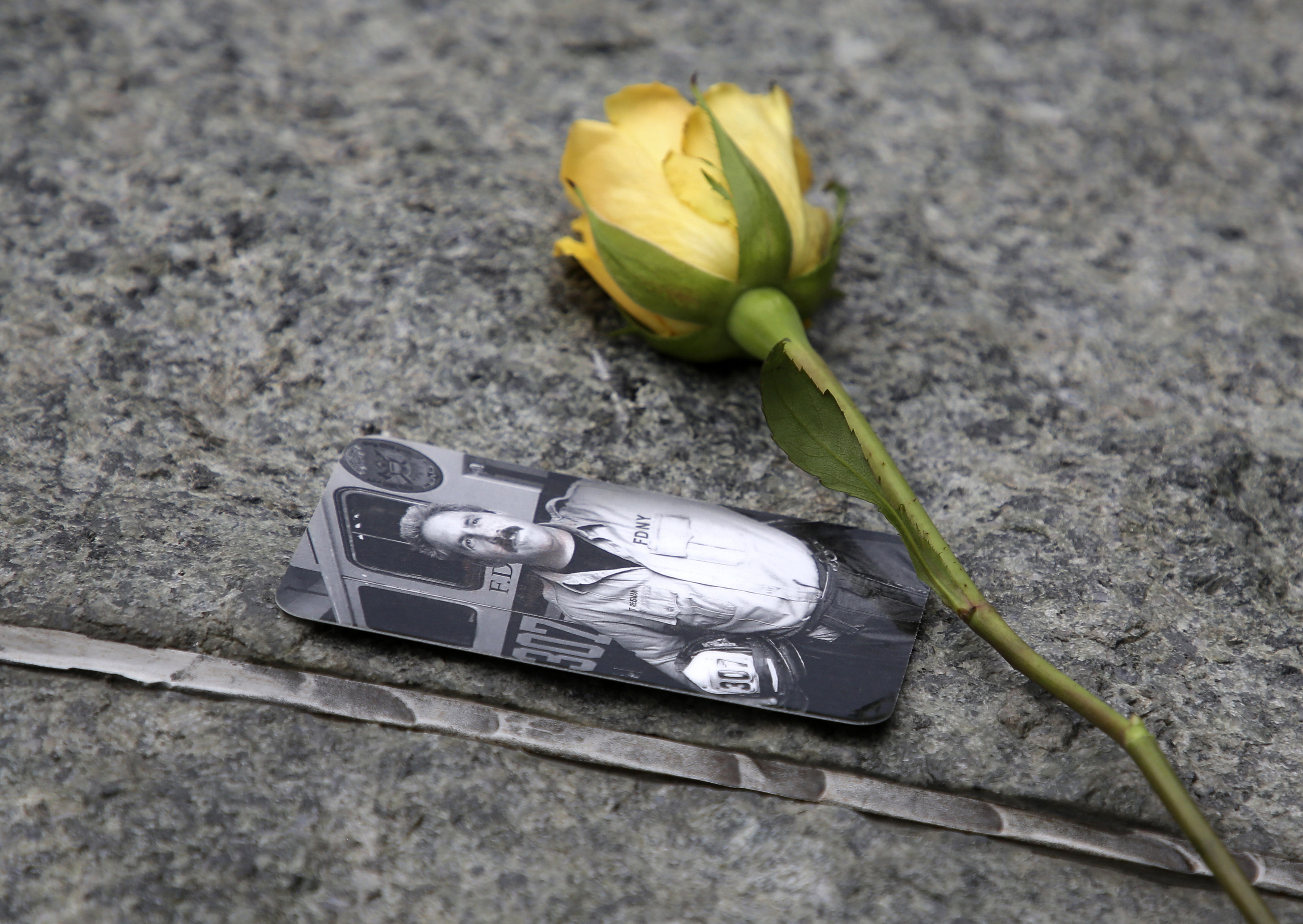 FILE - In this May 30, 2019 file photo, a rose rests next to a photograph of New York City Fire Department Lt. Steven Reisman in the 9/11 Memorial Glade near the National September 11 Memorial & Museum. Reisman searched through the World Trade Center debris for remains, and then died in 2014 of brain cancer at age 54. When the names of nearly 3,000 Sept. 11 victims are read aloud Wednesday, Sept. 11, 2019, at the World Trade Center, a half-dozen stacks of stone will quietly salute an untold number of people who aren’t on the list. Seth Wenig | AP FILE - In this May 30, 2019 file photo, a rose rests next to a photograph of New York City Fire Department Lt. Steven Reisman in the 9/11 Memorial Glade near the National September 11 Memorial & Museum. Reisman searched through the World Trade Center debris for remains, and then died in 2014 of brain cancer at age 54. When the names of nearly 3,000 Sept. 11 victims are read aloud Wednesday, Sept. 11, 2019, at the World Trade Center, a half-dozen stacks of stone will quietly salute an untold number of people who aren’t on the list. Seth Wenig | AP