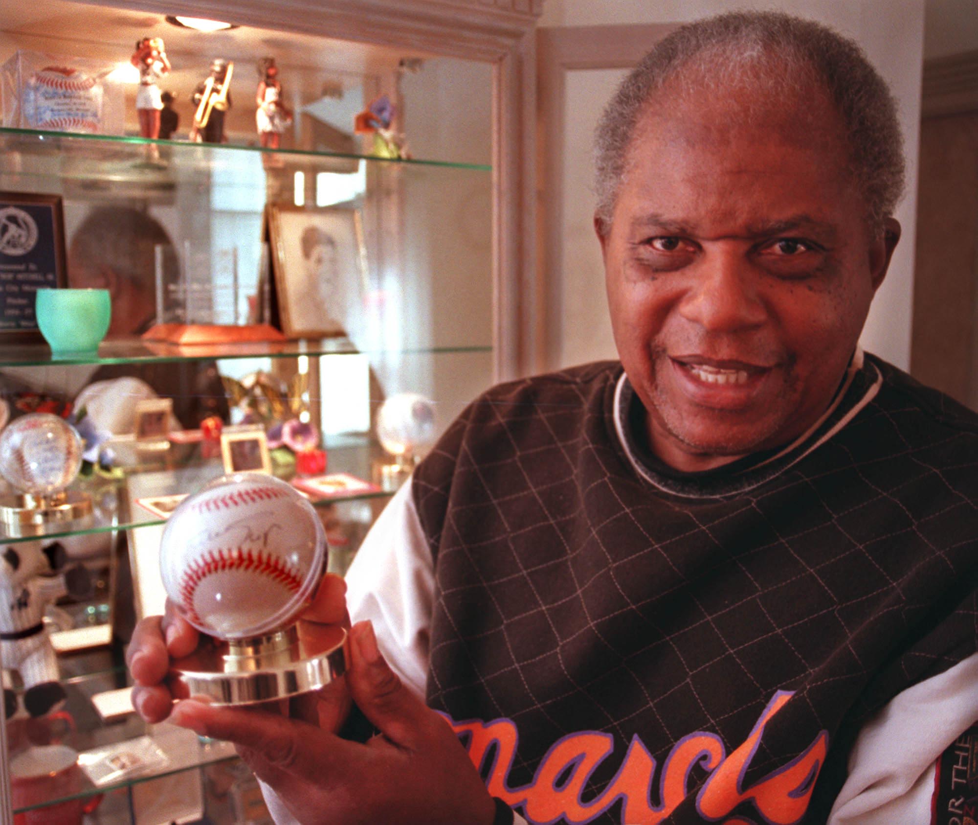 Former Negro League pitcher Bob Mitchell with a prized Willie Mays autographed baseball in his collection of memorabilia. (Times, 2001) Former Negro League pitcher Bob Mitchell with a prized Willie Mays autographed baseball in his collection of memorabilia. (Times, 2001)