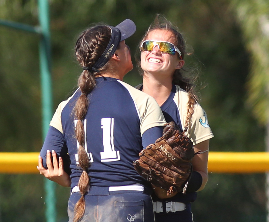 Admiral Farragut leftfielder Haley Saylor, right, gets a hug from shortstop Krystina Hartley moments after Saylor made a diving catch. (SCOTT PURKS | Special to the Times) Admiral Farragut leftfielder Haley Saylor, right, gets a hug from shortstop Krystina Hartley moments after Saylor made a diving catch. (SCOTT PURKS | Special to the Times)