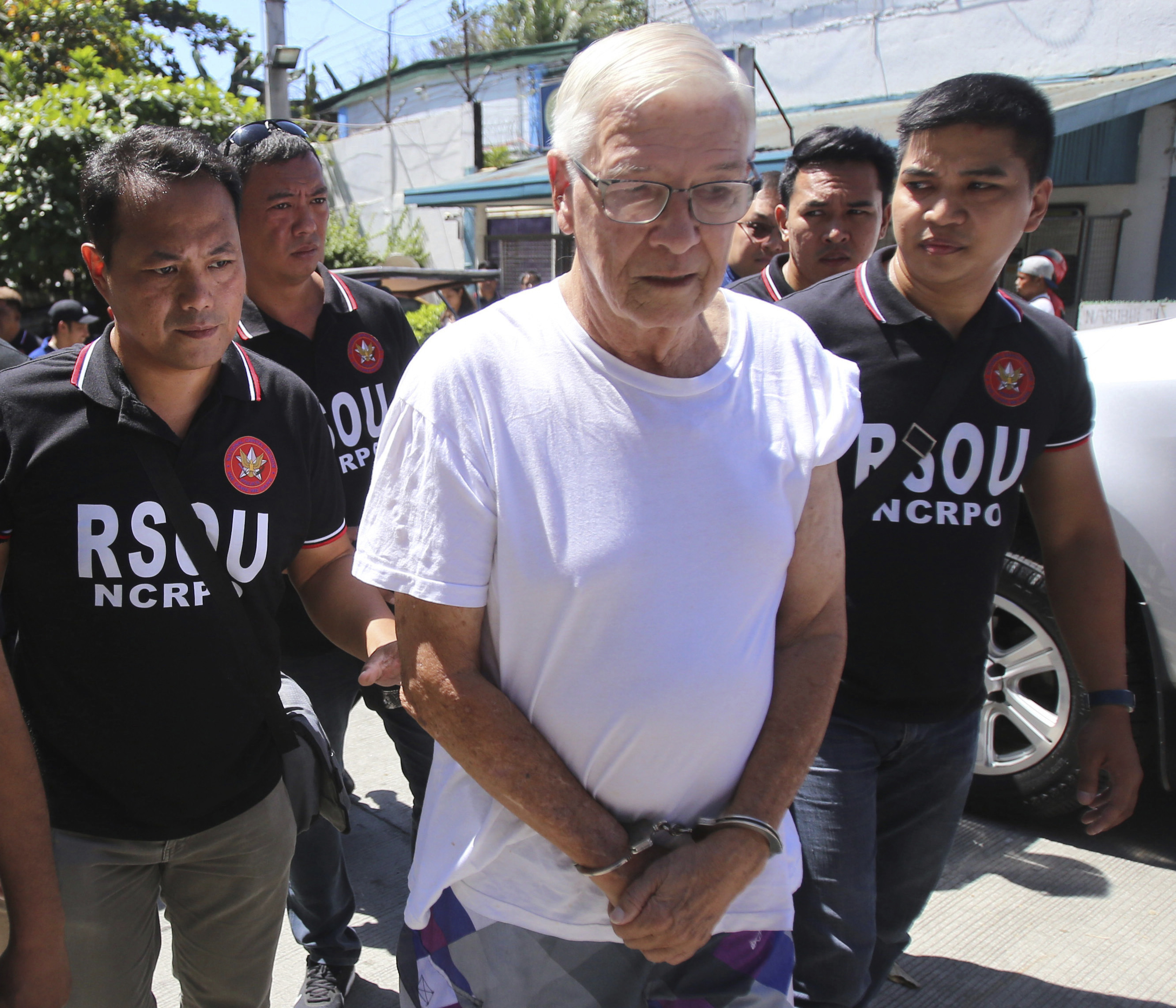 In this Feb. 19, 2019 photo, Philippine National Police, National Capital Region Police Office (NCRPO) agents escort Catholic priest Father Pius Hendricks to be served five additional arrest warrants at the Regional Special Operations Unit at Camp Bagong Diwa in suburban Taguig, east of Manila, Philippines. Investigators say about 20 boys and men, one as young as 7, have accused the priest of sexual abuse at his parish in Talustosan village, Naval township, Biliran province in central Philippines. AP In this Feb. 19, 2019 photo, Philippine National Police, National Capital Region Police Office (NCRPO) agents escort Catholic priest Father Pius Hendricks to be served five additional arrest warrants at the Regional Special Operations Unit at Camp Bagong Diwa in suburban Taguig, east of Manila, Philippines. Investigators say about 20 boys and men, one as young as 7, have accused the priest of sexual abuse at his parish in Talustosan village, Naval township, Biliran province in central Philippines. AP