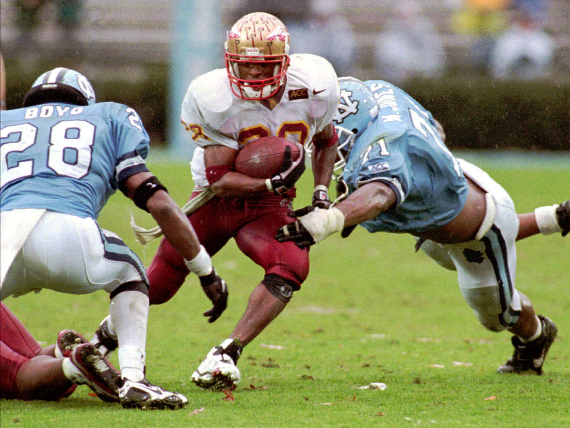 Florida State tailback Warrick Dunn, middle, cuts between North Carolina defenders Sean Boyd (28) and Marcus Jones, right, during action Nov. 11, 1995, in Chapel Hill, N.C. (Associated Press/Bob Jordan) Florida State tailback Warrick Dunn, middle, cuts between North Carolina defenders Sean Boyd (28) and Marcus Jones, right, during action Nov. 11, 1995, in Chapel Hill, N.C. (Associated Press/Bob Jordan)