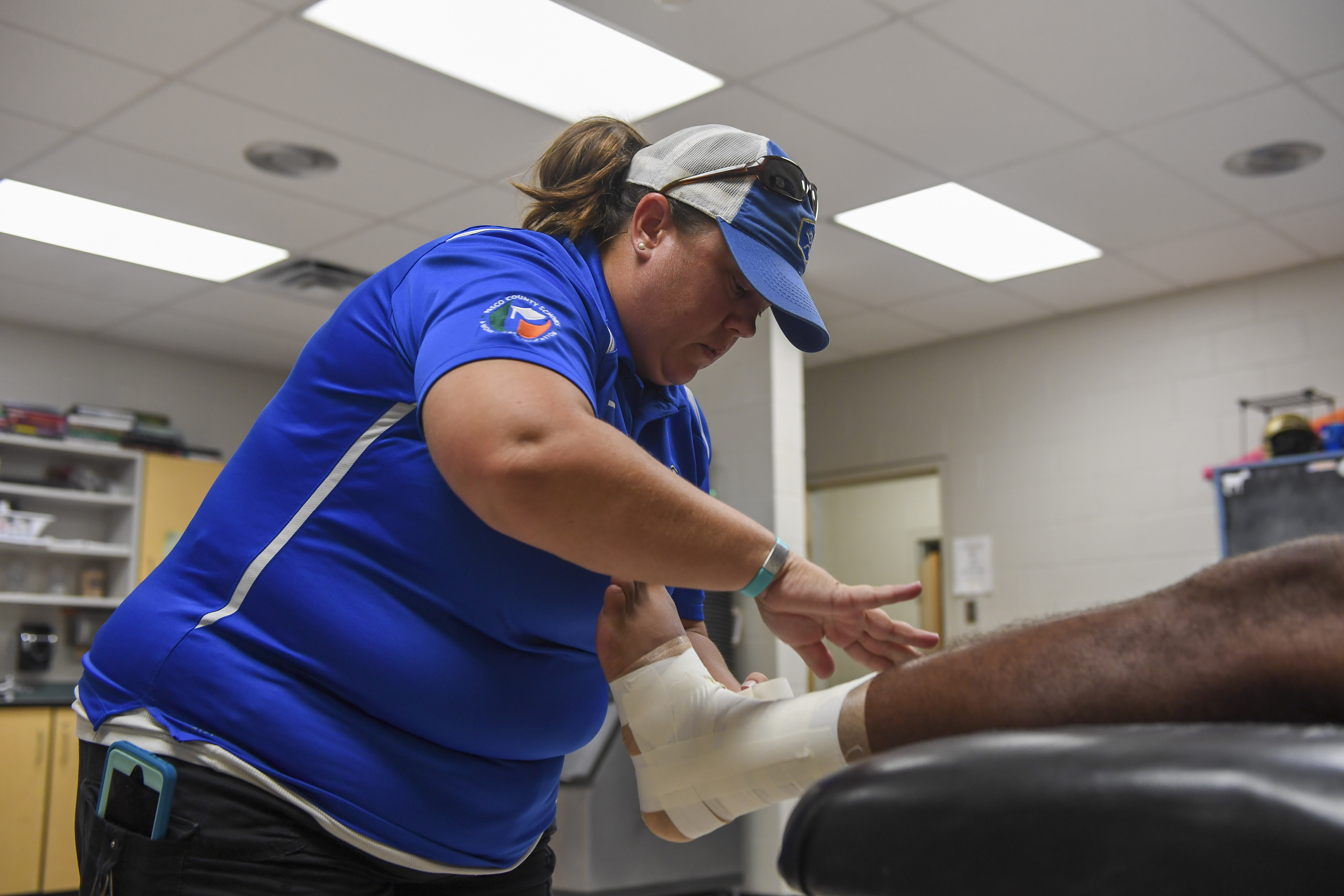 Sunlake High School athletic trainer Tara Mendres wraps an athlete's ankle before football practice on Tuesday, Aug. 06, 2019 in Land O' Lakes. ALLIE GOULDING | Times Tampa Bay Times Sunlake High School athletic trainer Tara Mendres wraps an athlete's ankle before football practice on Tuesday, Aug. 06, 2019 in Land O' Lakes. ALLIE GOULDING | Times Tampa Bay Times