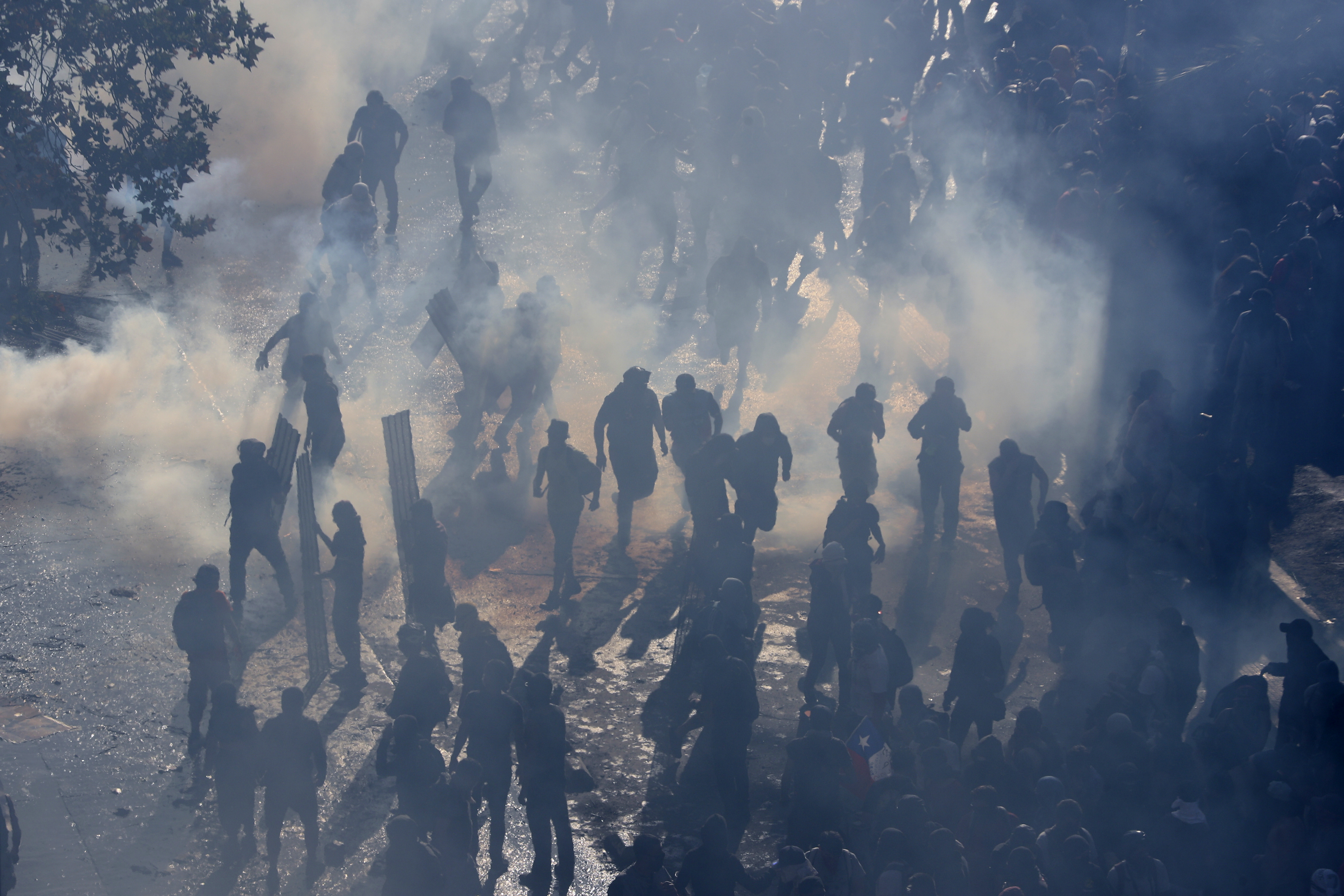 Protesters stand in tear gas launched by police amid ongoing demonstrations triggered by an increase in subway fares in Santiago, Chile, Monday, Oct. 21, 2019. Protesters defied an emergency decree and confronted police in Chile's capital on Monday, continuing disturbances that have left at least 11 dead. Esteban Felix | AP Protesters stand in tear gas launched by police amid ongoing demonstrations triggered by an increase in subway fares in Santiago, Chile, Monday, Oct. 21, 2019. Protesters defied an emergency decree and confronted police in Chile's capital on Monday, continuing disturbances that have left at least 11 dead. Esteban Felix | AP