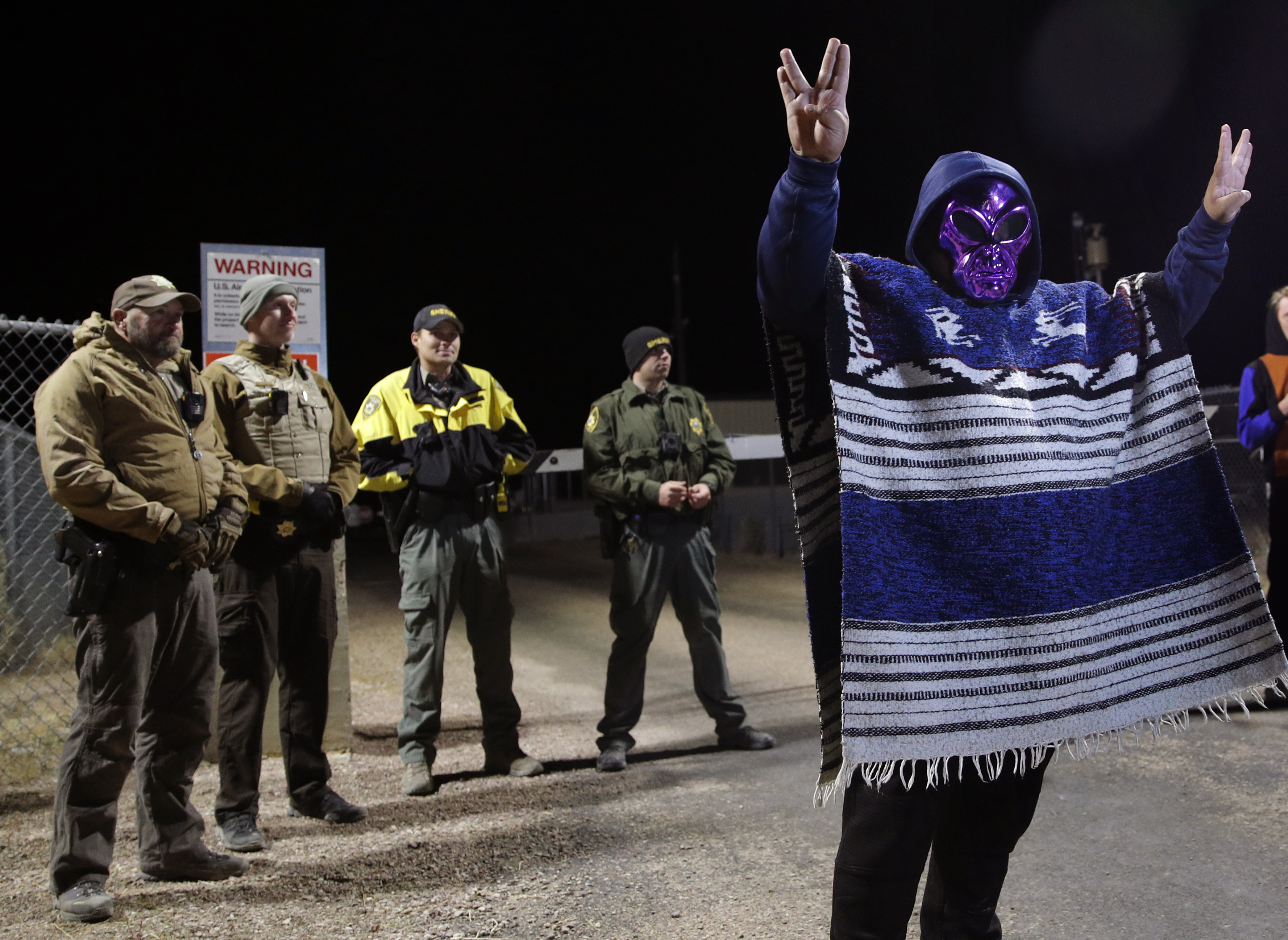 A man in an alien mask stands at an entrance to the Nevada Test and Training Range near Area 51 Friday, Sept. 20, 2019, outside of Rachel, Nev. People gathered at the gate inspired by the A man in an alien mask stands at an entrance to the Nevada Test and Training Range near Area 51 Friday, Sept. 20, 2019, outside of Rachel, Nev. People gathered at the gate inspired by the