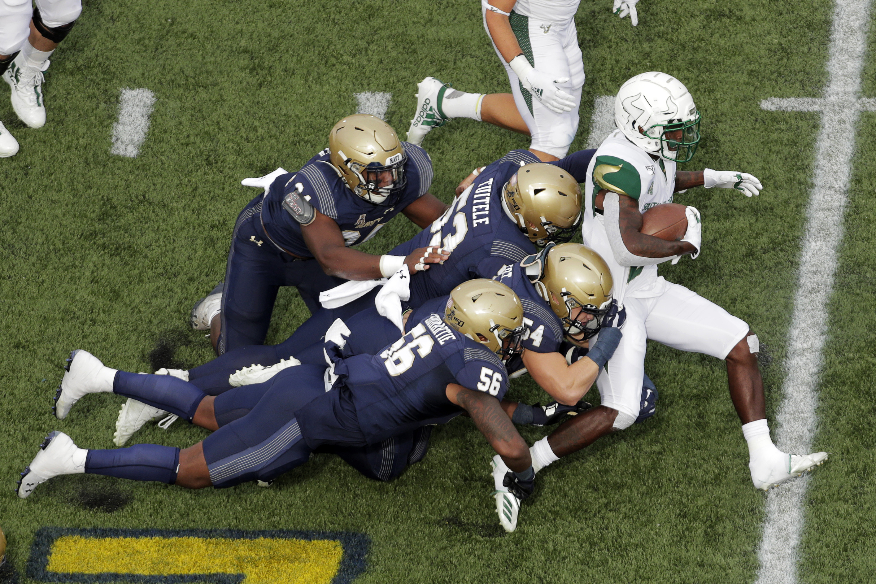 USF running back Jordan Cronkrite, right, runs the ball as Navy linebackers Nizaire Cromartie (56), Diego Fagot (54) and Tama Tuitele (53) and defensive tackle J'arius Warren (94) try to bring him down. Julio Cortez | AP USF running back Jordan Cronkrite, right, runs the ball as Navy linebackers Nizaire Cromartie (56), Diego Fagot (54) and Tama Tuitele (53) and defensive tackle J'arius Warren (94) try to bring him down. Julio Cortez | AP