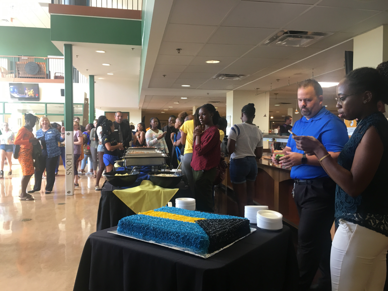 Saint Leo University graduate assistant Giana Fernander takes a photo of the Bahamian flag cake at Tuesday's comfort food dinner. Fernander helped organized the dinner to bring the university's Bahamian students together after Hurricane Dorian. Saint Leo University graduate assistant Giana Fernander takes a photo of the Bahamian flag cake at Tuesday's comfort food dinner. Fernander helped organized the dinner to bring the university's Bahamian students together after Hurricane Dorian.