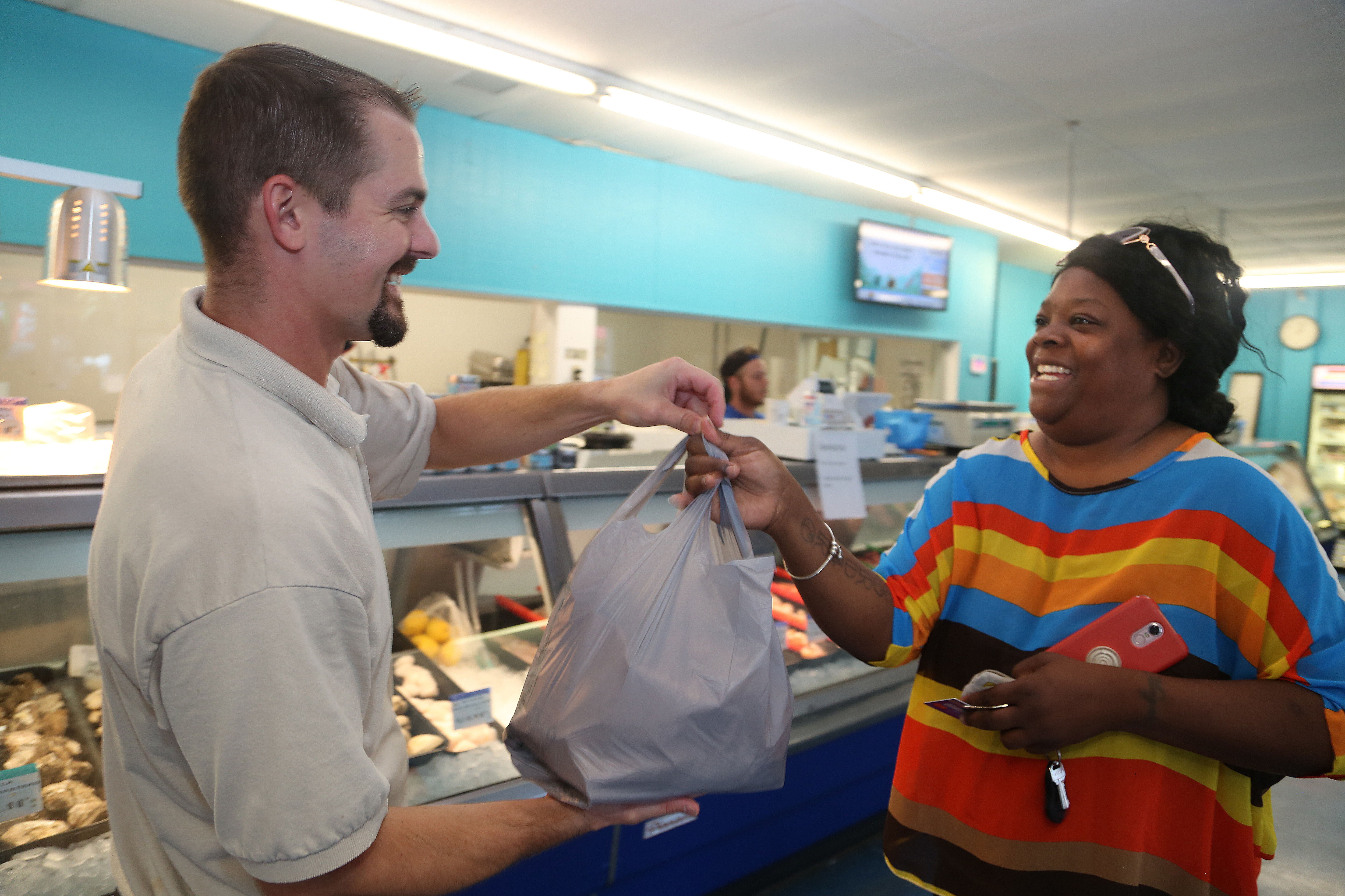 CJ Hnilica, manager of Key West Seafood Company, Gulfport, gives customer Mayah Shazel, 41, St. Petersburg, her order of blue crabs at the store, Wednesday, October 2, 2019. CJ Hnilica, manager of Key West Seafood Company, Gulfport, gives customer Mayah Shazel, 41, St. Petersburg, her order of blue crabs at the store, Wednesday, October 2, 2019.