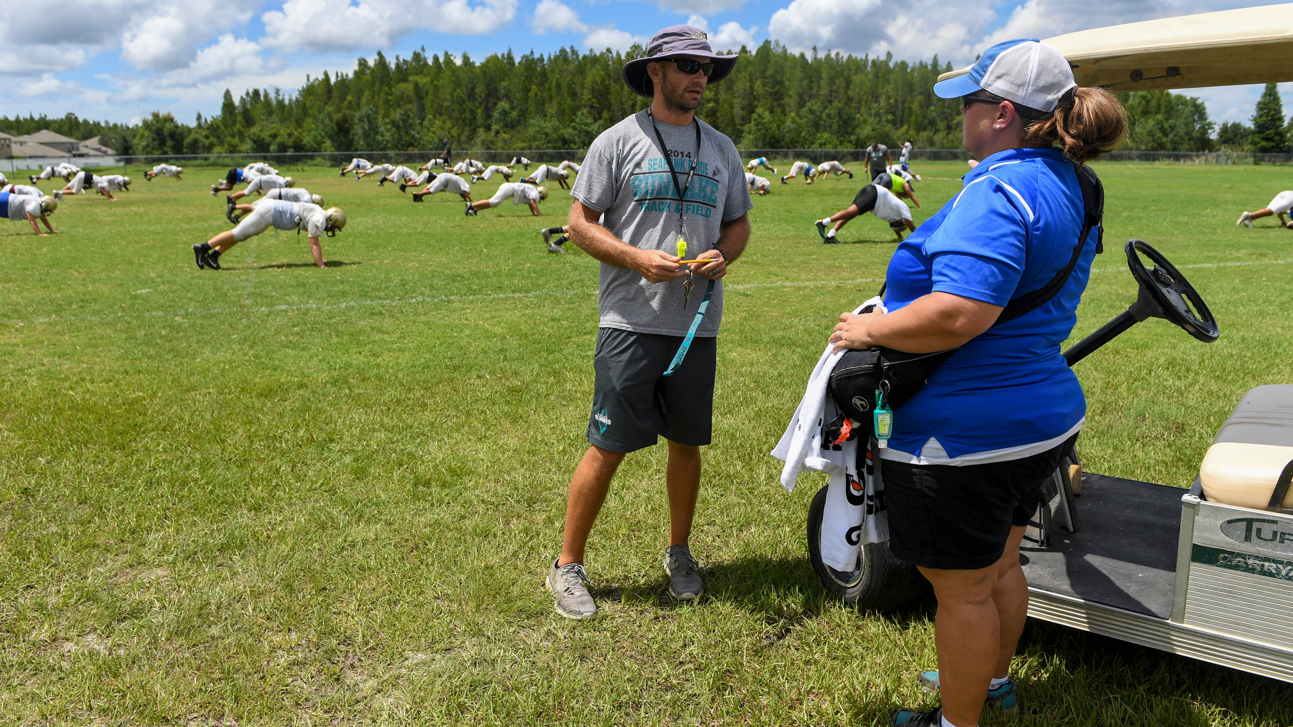 Sunlake High School athletic trainer Tara Mendres talks to head coach Trey Burdick while athletes warm up for football practice on Tuesday, Aug. 06, 2019 in Land O' Lakes. ALLIE GOULDING | Times Tampa Bay Times Sunlake High School athletic trainer Tara Mendres talks to head coach Trey Burdick while athletes warm up for football practice on Tuesday, Aug. 06, 2019 in Land O' Lakes. ALLIE GOULDING | Times Tampa Bay Times